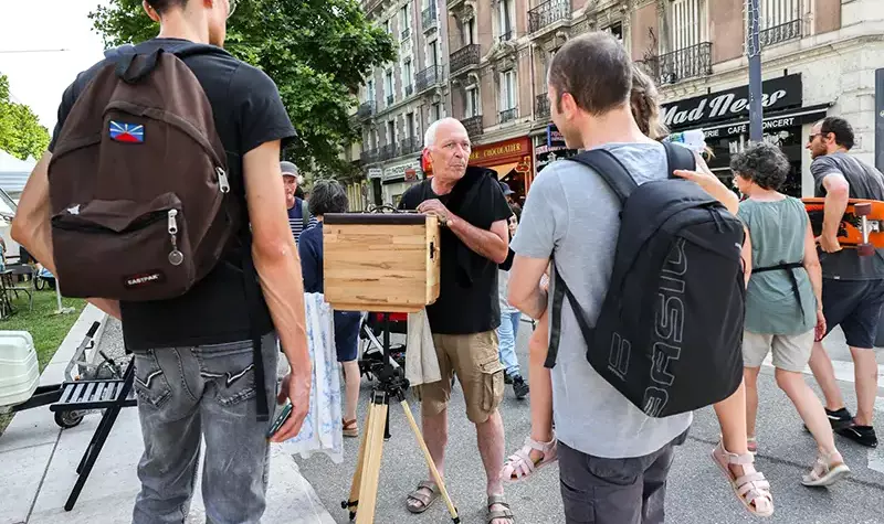 Un photographe donne des explications sur une chambre photographique.