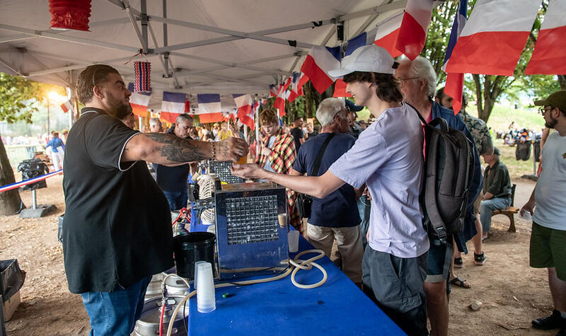 Un homme sert un verre de bière à une personne