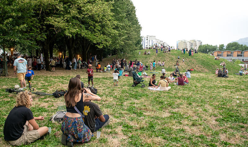 Des personnes sont installées dans l'herbe