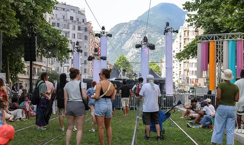 La scène est installée sur les rails du tram. Le public profite.