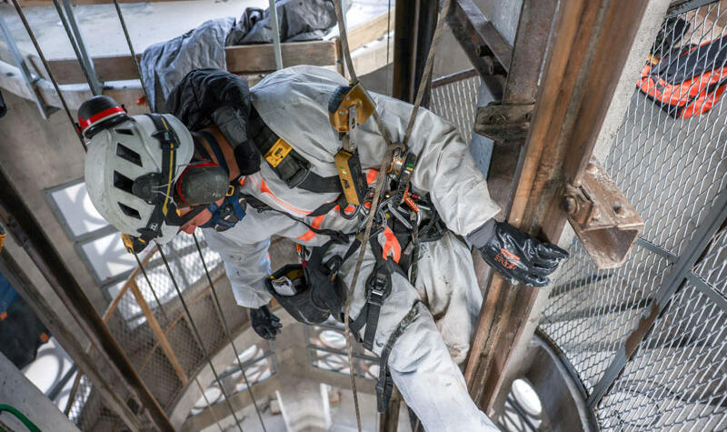 Un ouvrier ajuste son baudrier.