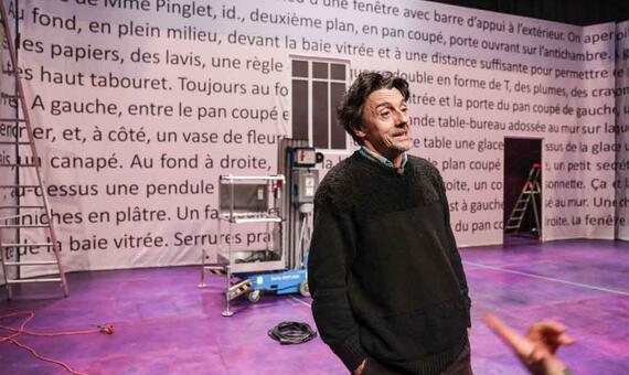Stanislas Nordey, metteur en scène, dévoile la scène de son spectacle. Sur les murs, des didascalies écrites par Feydeau.