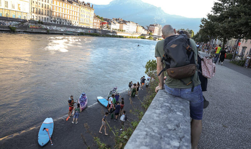 Des personnes s'apprêtent à faire du paddle sur l'Isère.
