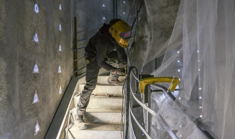 Un ouvrier travaille sur la main courante.