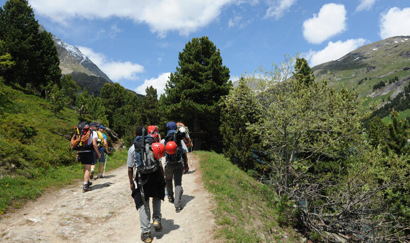 Un groupe de personnes marchent en montagne. 