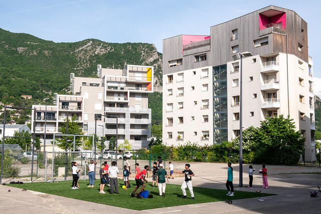 Photo un terrain de mini-foot avec des enfants qui jouent au milieu des immeubles de la Presqu'île.