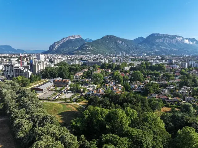 Photo en hauteur du parc Jean Verlhac, des immeubles de la Villeneuve et au loin, la vue sur Grenoble