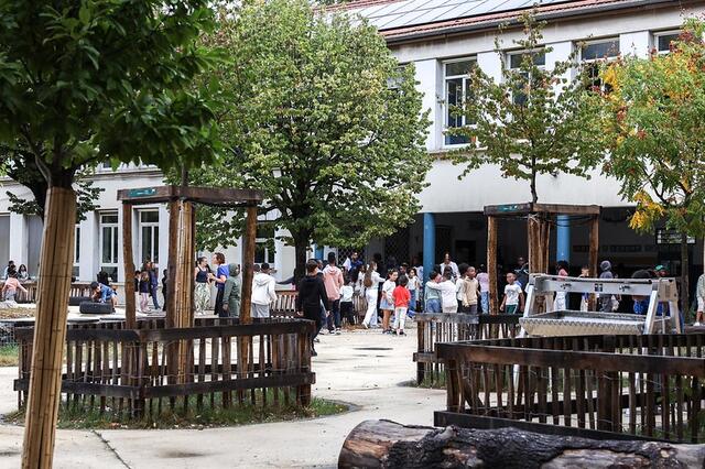 Des enfants se rassemblent dans une cour de récréation.