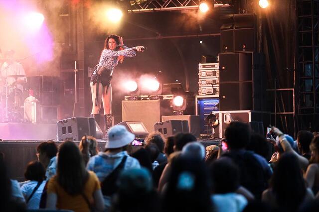Une artiste incite le public à chanter.