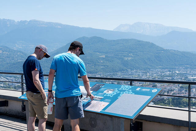 Deux hommes regardent les tables d'orientation sur le belvédère de la Bastille