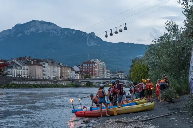 Photo d'enfants et d'adultes montant sur des kayak au bord de l'Isère