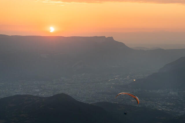 Photo de l'éclipse. On y voit Grenoble en contre-bas, les contre-forts du Vercors et un parapentiste.