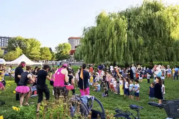 Des enfants et des habitants écoutent une fanfare habillée en rose dans le parc Ouagadougou.