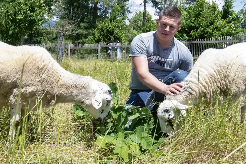 Le berger pose avec deux brebis.
