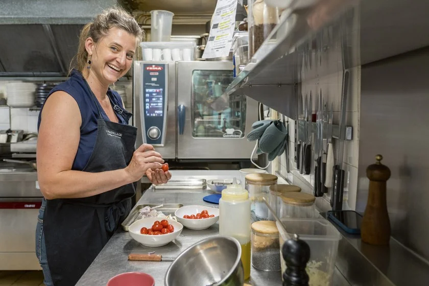 La cheffe prépare les tomates cerises.