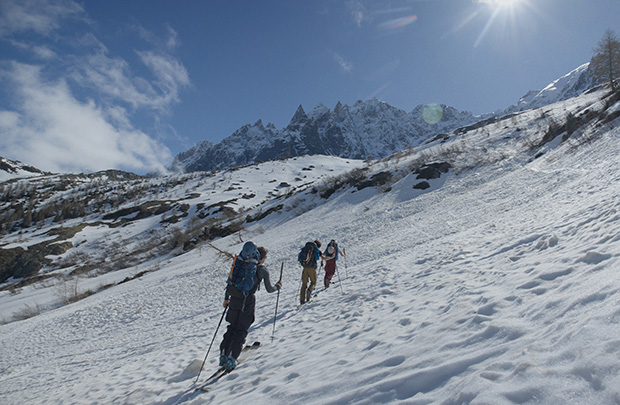 3 skieurs de randonnée remontent une pente