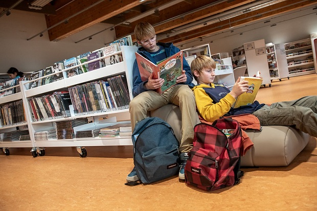 Deux adolescents lisent des bandes dessinées dans la bibliothèque Chantal Mauduit