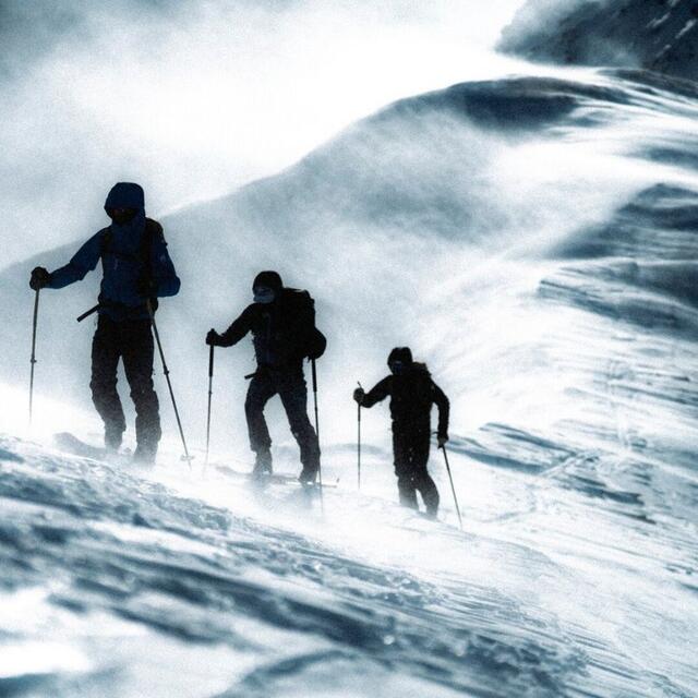 Trois personnes montant en ski dans la neige.