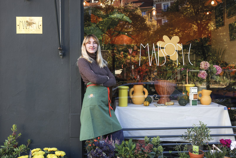 La fleuriste pose devant sa boutique.