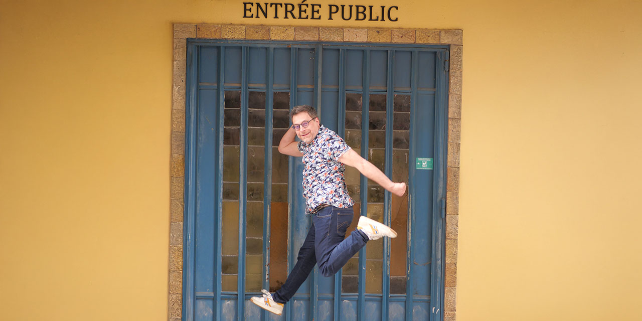 Grégory Faive sautant devant l'entrée du théâtre