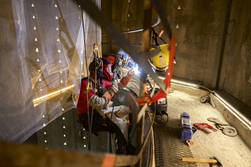 Image d'un ouvrier en train de souder la main courante.